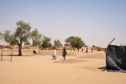 mensen in Niger lopen door uitgedroogd gebied