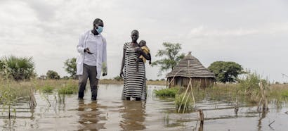 James van IRC en Abuk houden Nyirou vast in de overstromingen rond Abuk's Tukul, in het noorden van Bahr El Ghazal, Zuid-Soedan, zaterdag 16 oktober 2021.