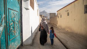 Vrouw loopt met kind door de straten van Kabul