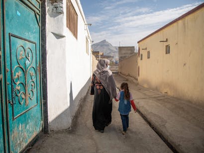 Vrouw loopt met kind door de straten van Kabul