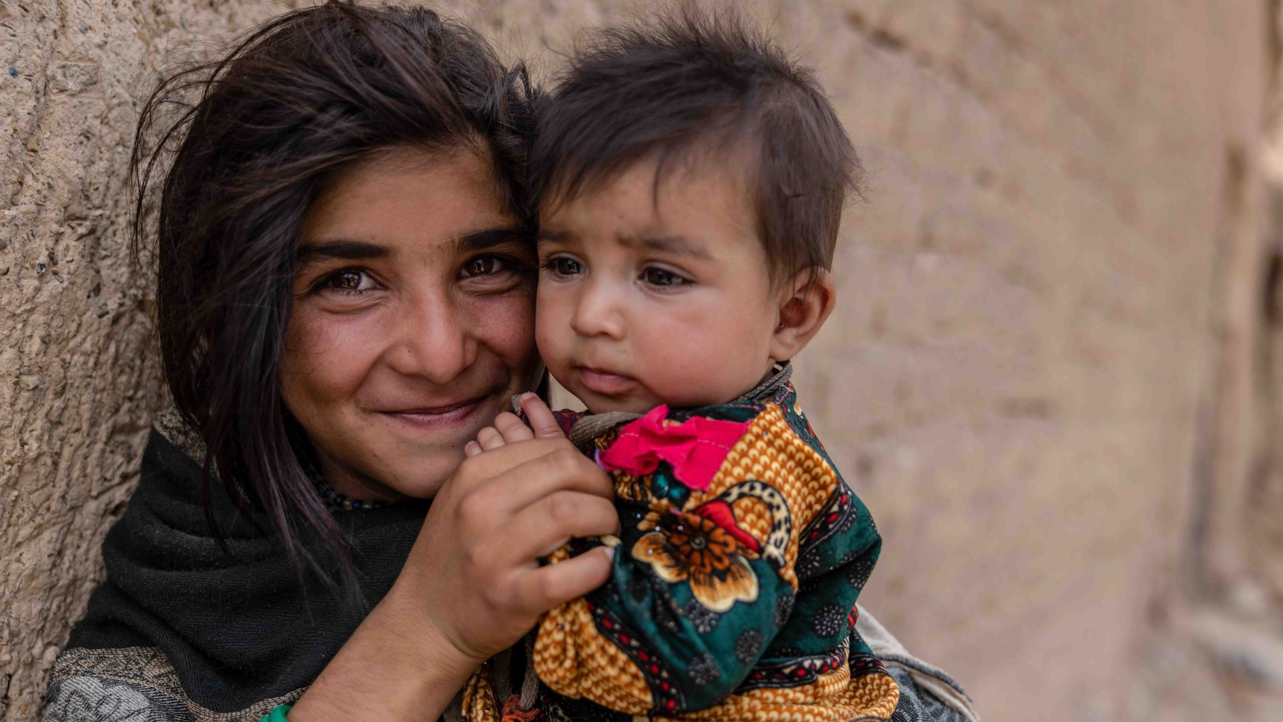 Portretfoto van meisje met jongen in haar armen