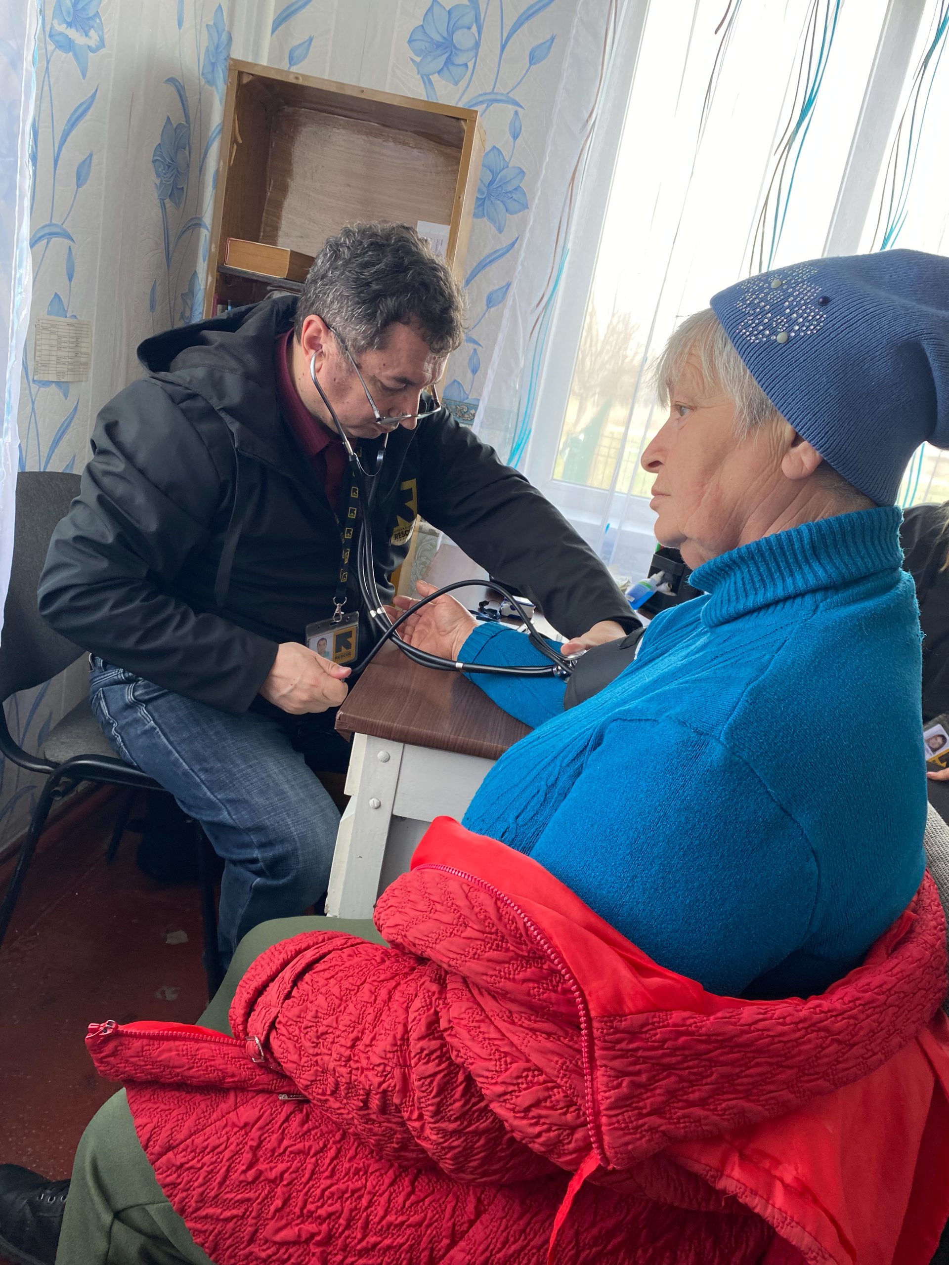 Arkadiivka-dorp, regio Kharkiv, Oekraïne. Leden van de medische eenheid van het IRC, Stanislav en dr. Oleg, praten met de patiënt Zoila, een plaatselijke bewoner.