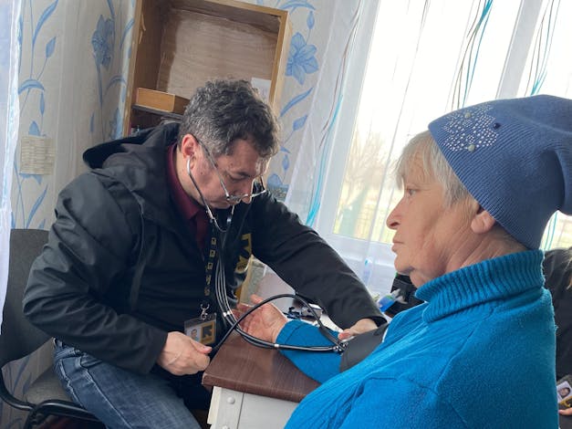 Arkadiivka-dorp, regio Kharkiv, Oekraïne. Leden van de medische eenheid van het IRC, Stanislav en dr. Oleg, praten met de patiënt Zoila, een plaatselijke bewoner.