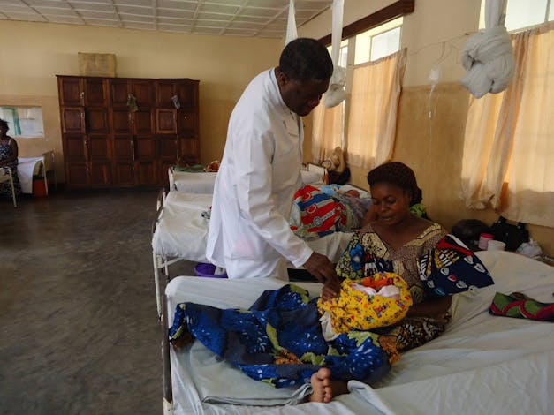 Dr Denis Mukwege bij moeder met kind bij ziekenhuisbed