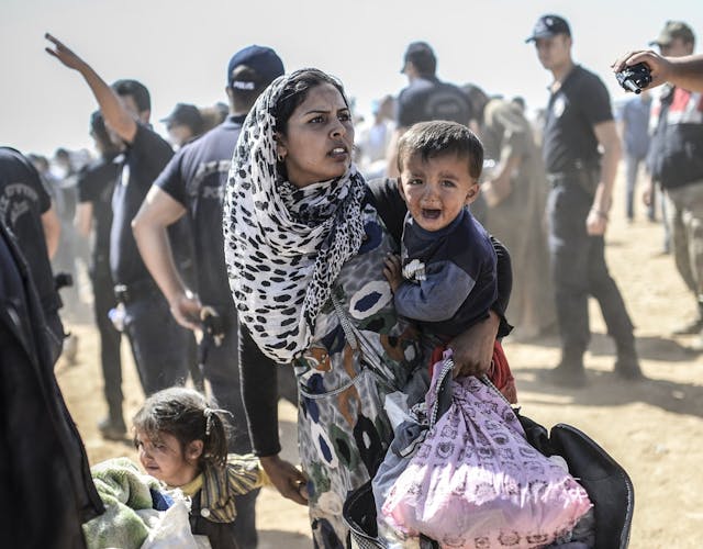 Vrouw houdt kind vast in Syrië