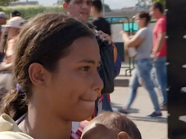 Vrouw draagt baby in haar handen onderweg naar Colombia