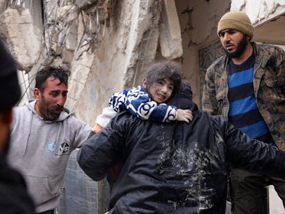 Meisje wordt gered door hulpverlener in Syrië