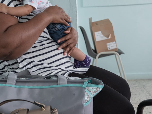 Vrouw houdt baby vast met beide armen