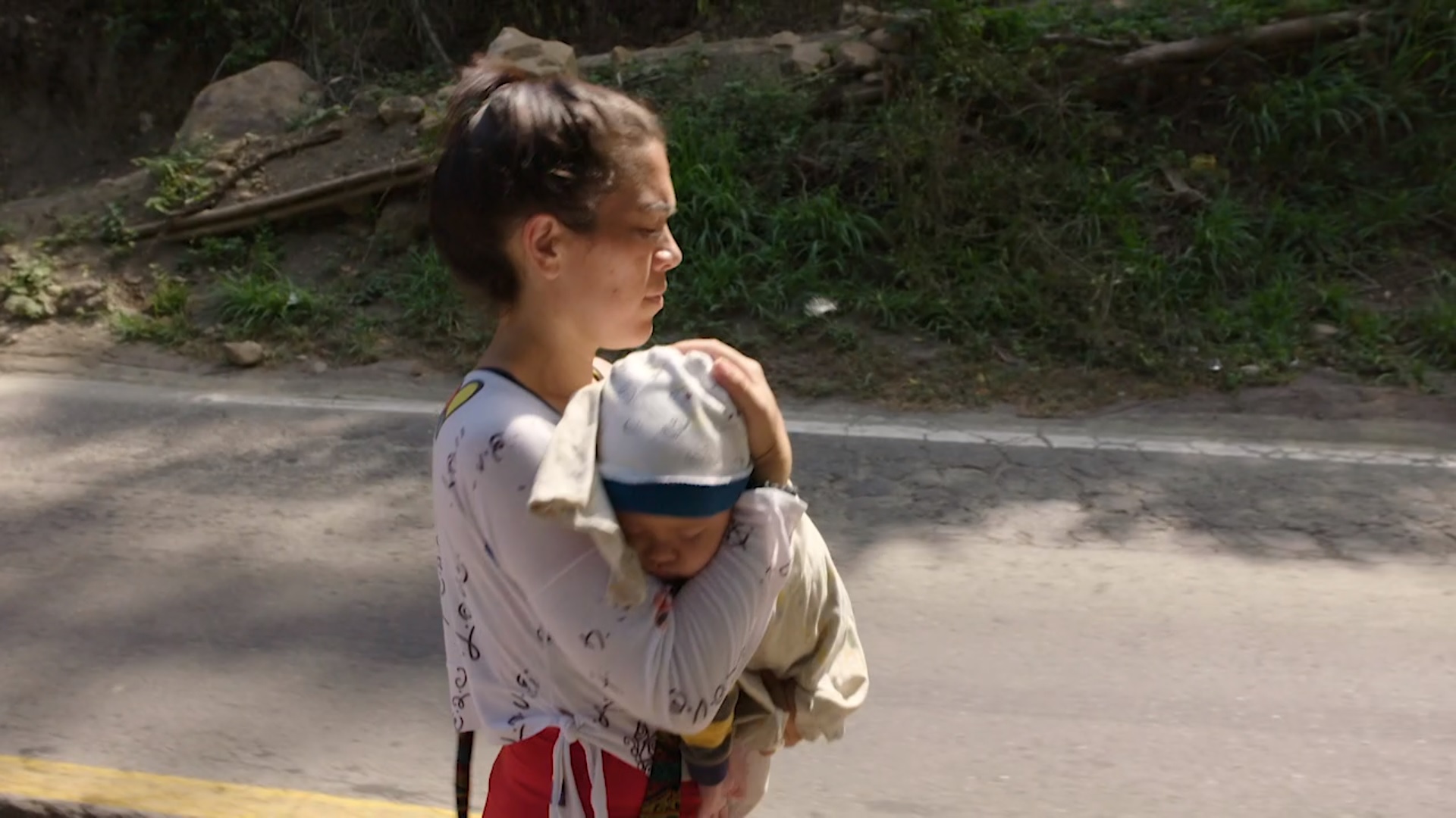 Vrouw houdt baby vast terwijl ze loopt
