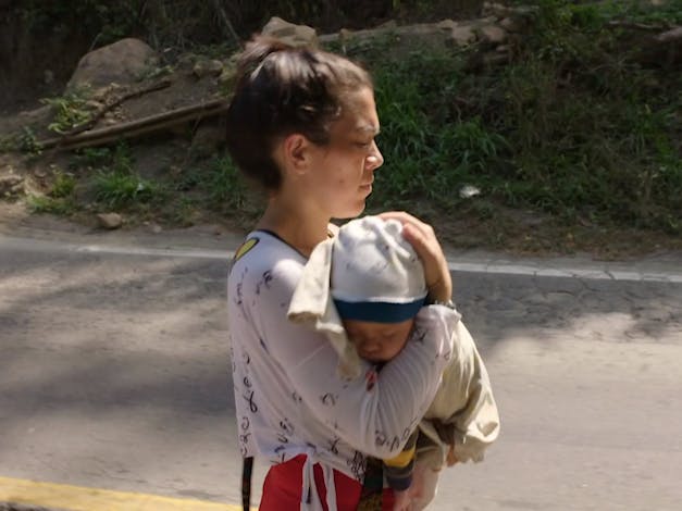 Vrouw houdt baby vast terwijl ze loopt