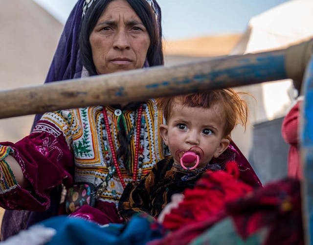 Portretfoto van moeder met dochter op schoot in Afghanistan