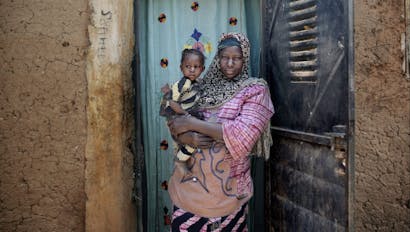 Portret van Adiara Doumbia en haar dochter Rokia Doumbia (20 maanden) voor hun huis in Mali.