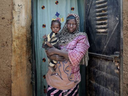 Portret van Adiara Doumbia en haar dochter Rokia Doumbia (20 maanden) voor hun huis in Mali.