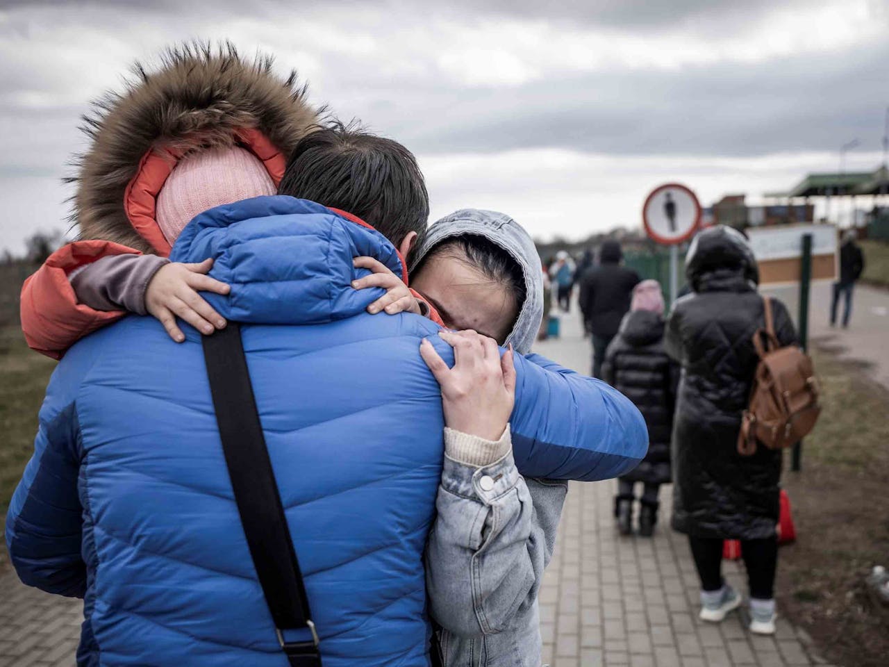 De Oekraïense Ivan omhelst zijn kleindochter Diana (4, l) en een dochter Olena (r) vlak nadat ze de grens van Shehyni in Oekraïne naar Medyka in Polen zijn overgestoken. Talrijke Oekraïners verlaten het land na de militaire acties van Rusland op Oekraïens grondgebied.