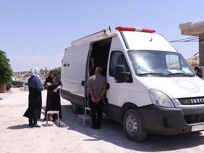 Ontheemden ontvangen zorg bij een mobiele kliniek van Stichting Vluchteling