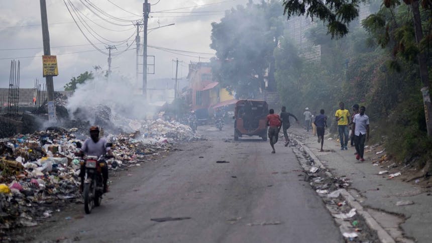 Mensen rennen op de weg waar rook komt van afval langs de weg