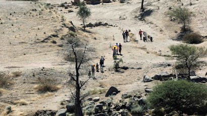 Beeld van bovenaf van mensen die trekken door droog gebied in Noord-Ethiopië
