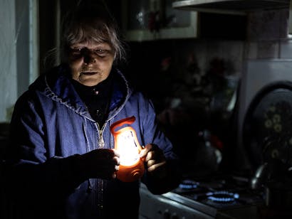 Vrouw in het donker met lampje in haar handen
