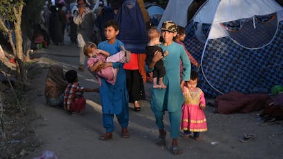 Jonge jongens met kinderen in hun armen in Afghanistan
