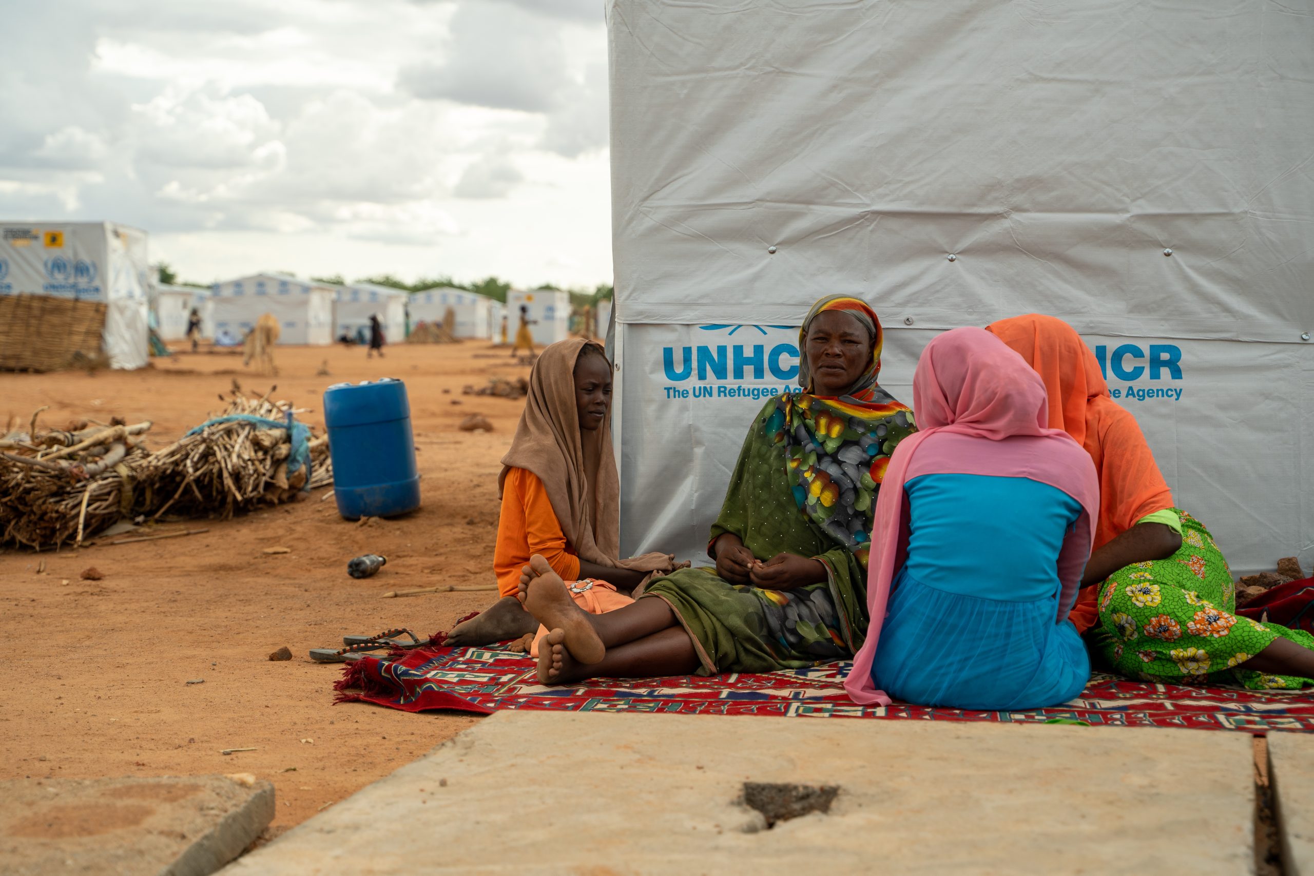 Vier vrouwen zitten voor tent in Tsjaad