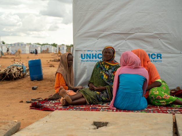 Vier vrouwen zitten voor tent in Tsjaad