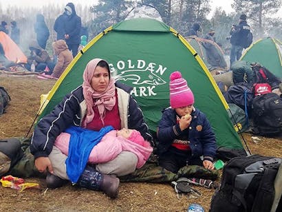 Kinderen zitten voor tent in grensgebied Wit-Rusland en Polen