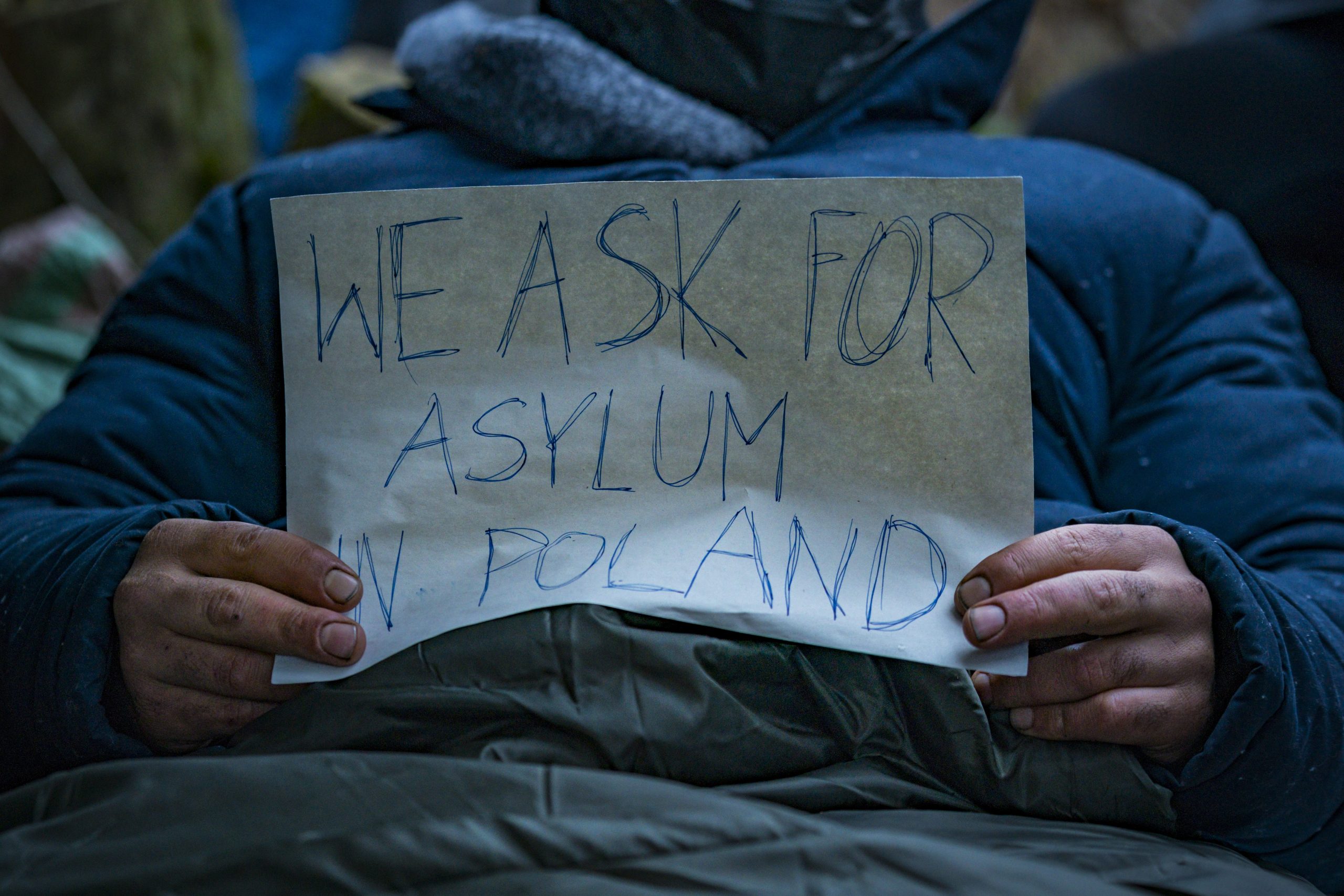 Klein spandoek met de vraag om asiel in Polen in de handen van een Syrische vluchteling gevonden in de bossen in de buurt van de grens met Wit-Rusland.