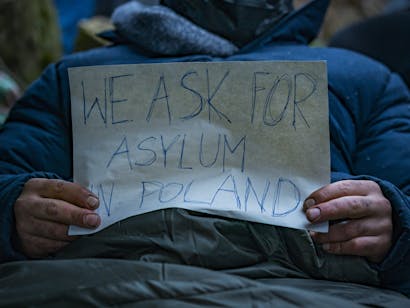 Klein spandoek met de vraag om asiel in Polen in de handen van een Syrische vluchteling gevonden in de bossen in de buurt van de grens met Wit-Rusland.