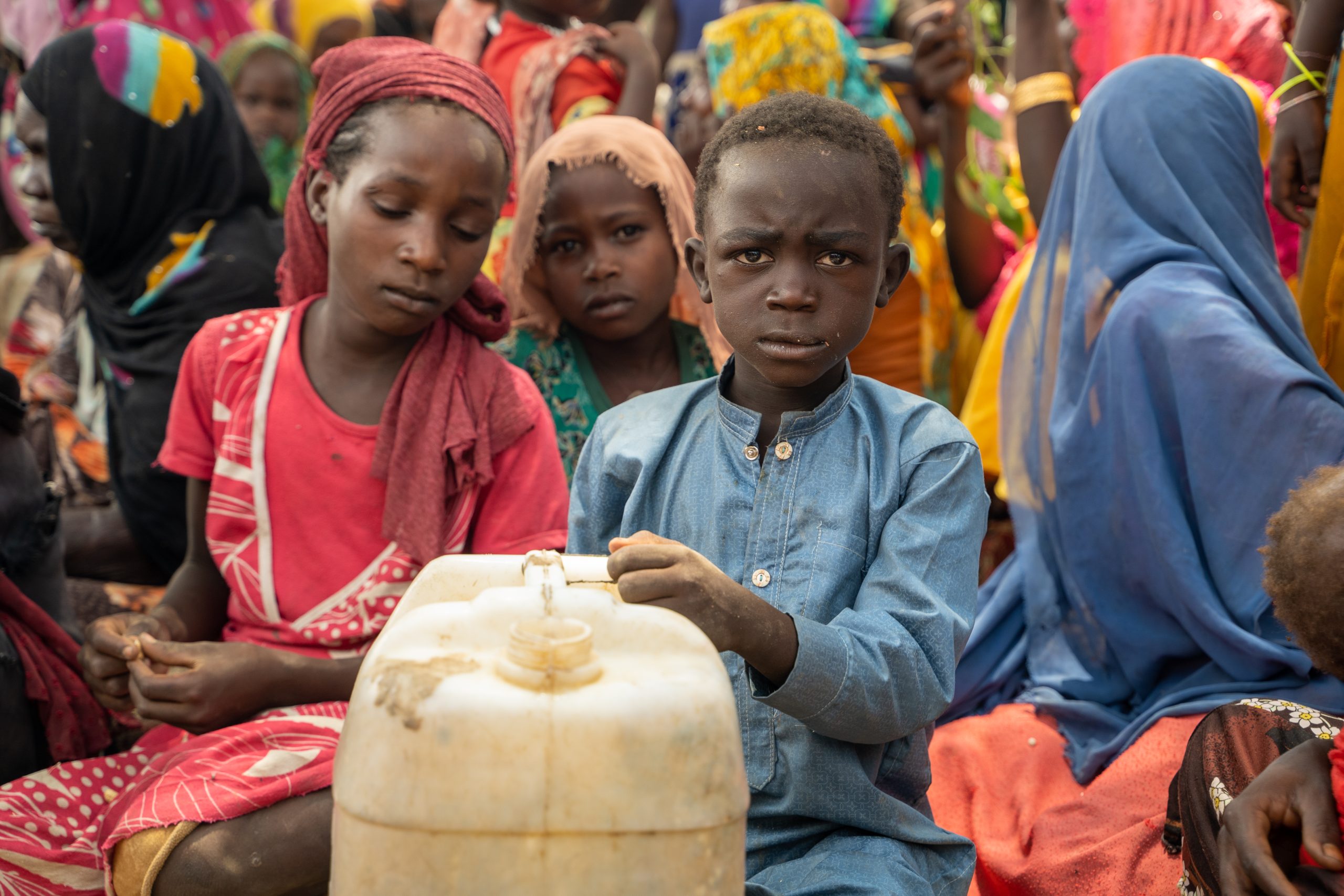 Kind met jerrycan in drukke menigte