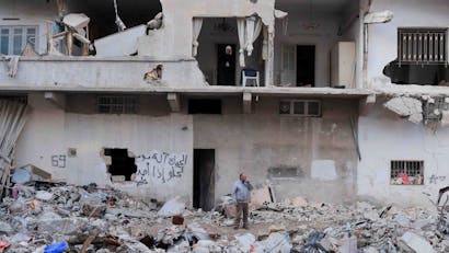 Man staat tussen totale verwoesting van de aardbeving in Syrië