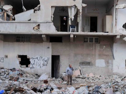 Man staat tussen totale verwoesting van de aardbeving in Syrië