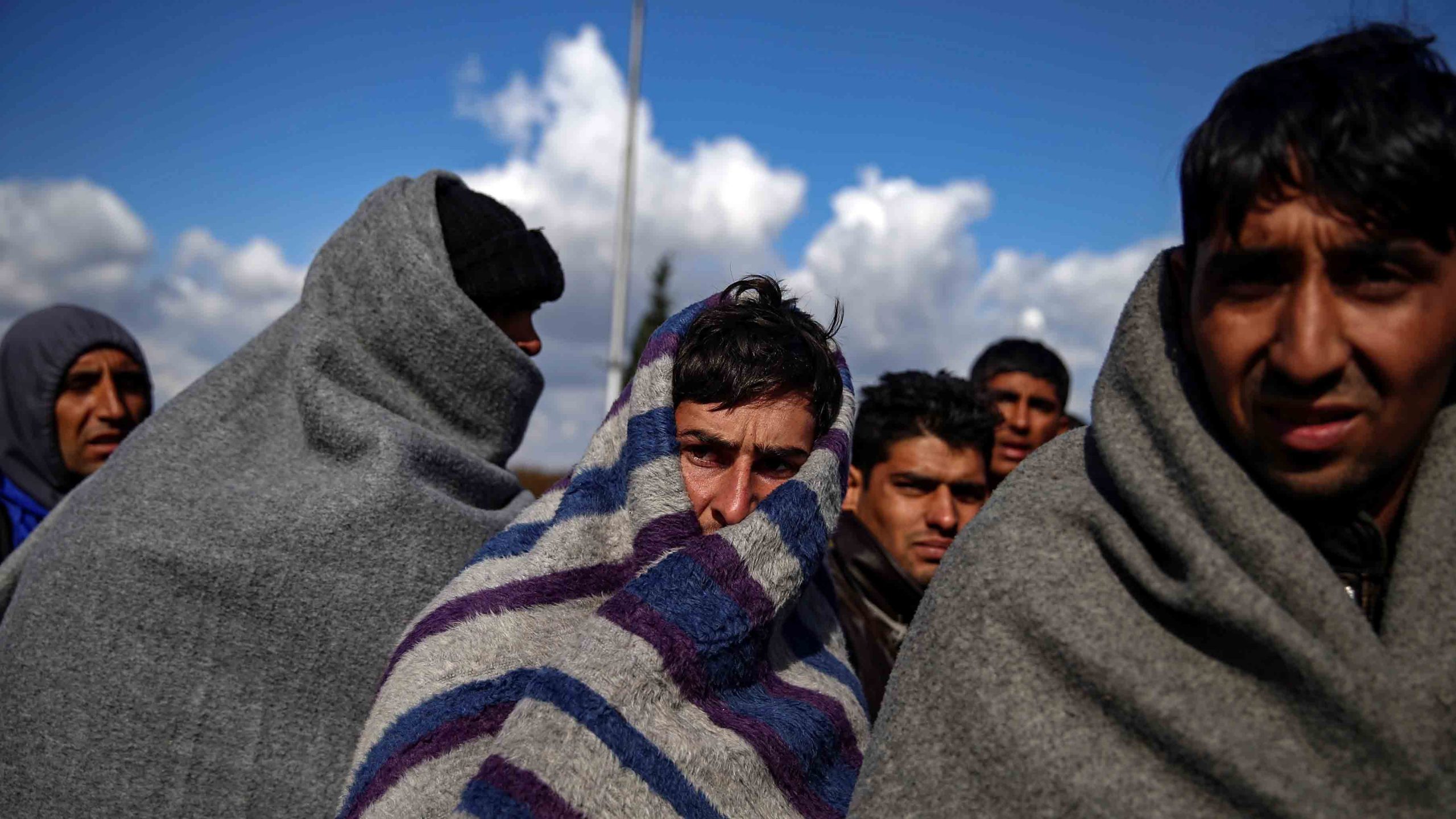 Portretfoto van vluchtelingen die zichzelf warm houden met dekens