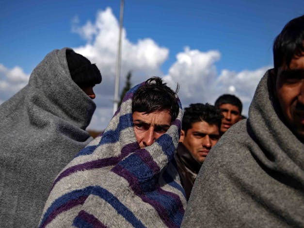 Portretfoto van vluchtelingen die zichzelf warm houden met dekens