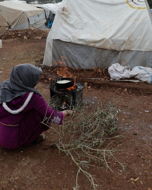 vrouw kookt in vluchtelingenkamp