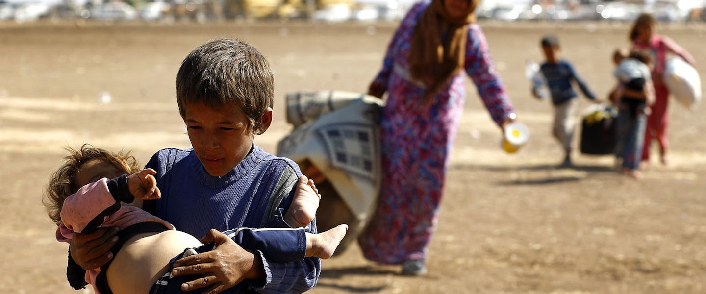Jongen met klein meisje in zijn armen in Syrië