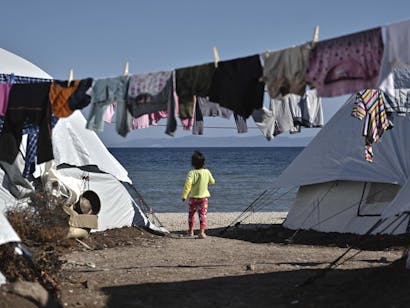 Meisje staat tussen tenten in bij de zee