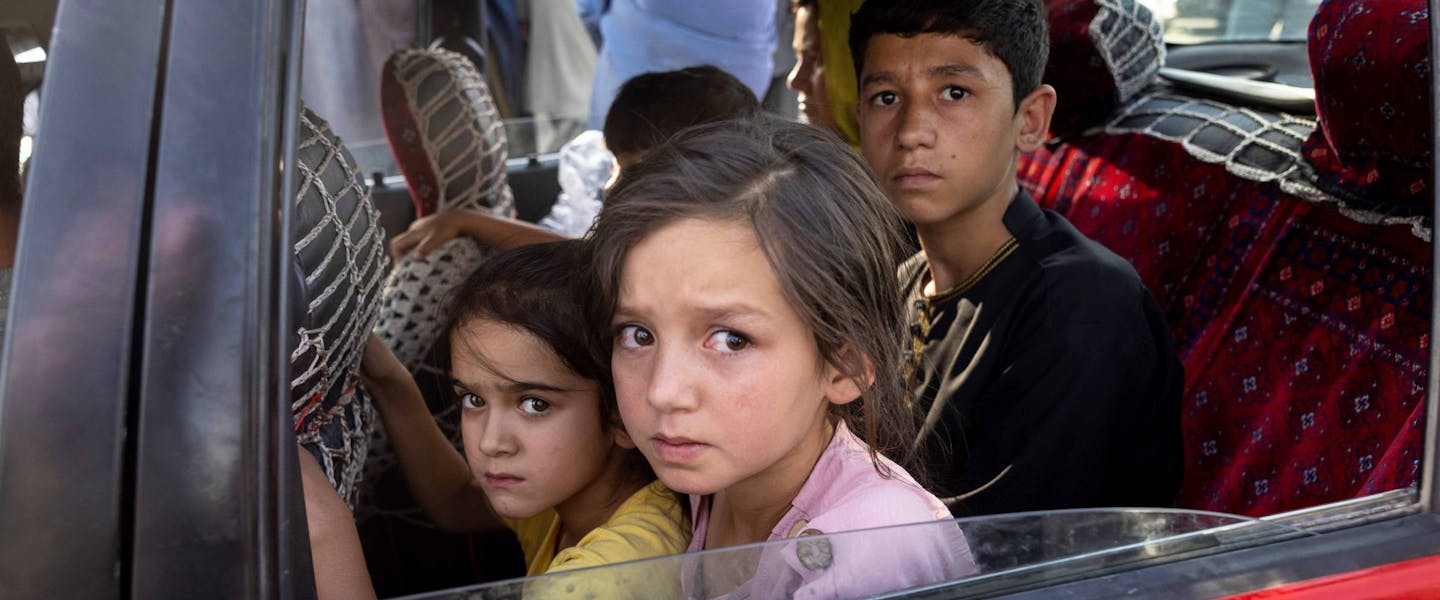 Kinderen op de achterbank van een auto in Kabul