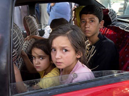 Kinderen op de achterbank van een auto in Kabul