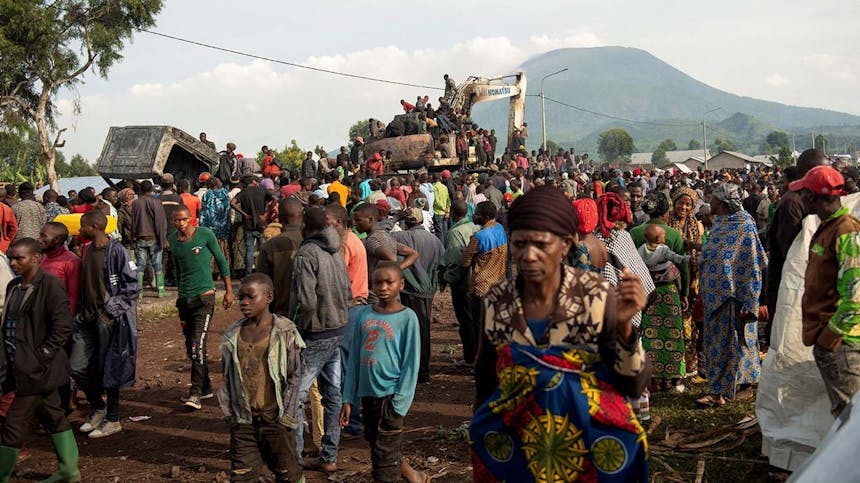 Grote groep mensen staan om bulldozer heen in Congo