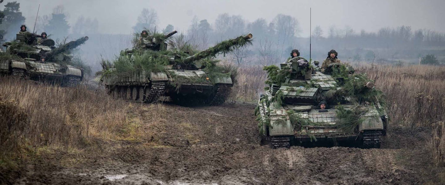 Drie tanks rijden door trainingsveld