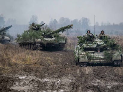 Drie tanks rijden door trainingsveld