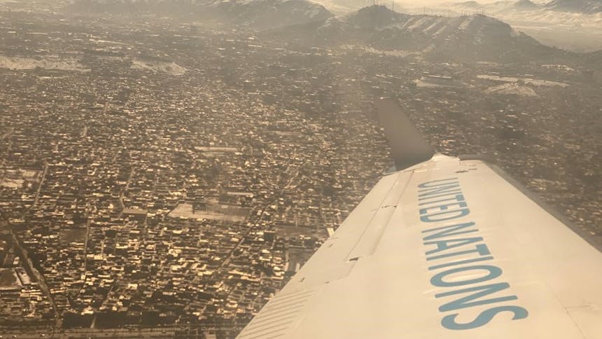 Vleugel van vliegtuig te zien van United Nation over Kabul in Afghanistan