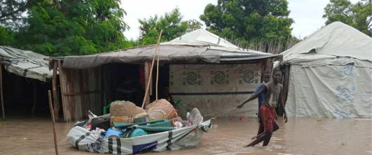Jongen trekken zijl in overstroomd gebied door water