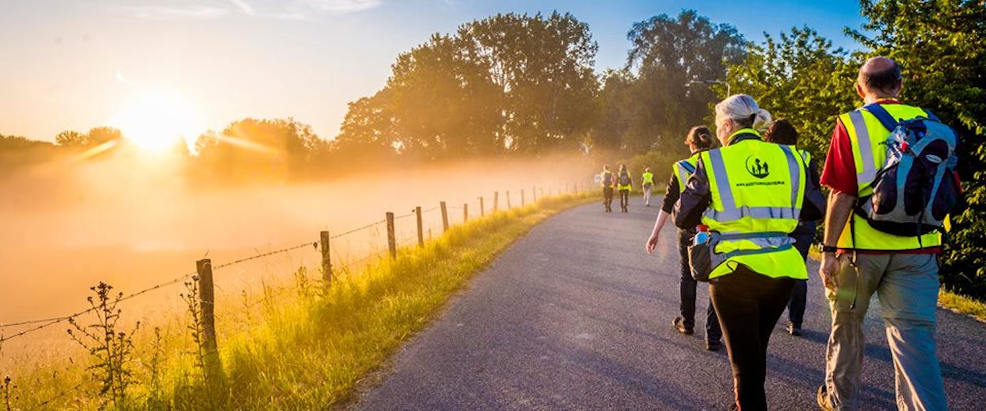 Deelnemers lopen in groep door mistige omgeving