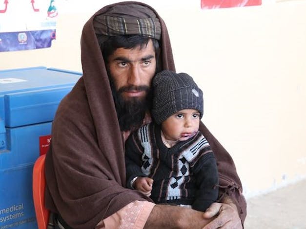 Man in Afghanistan met zoontje op schoot