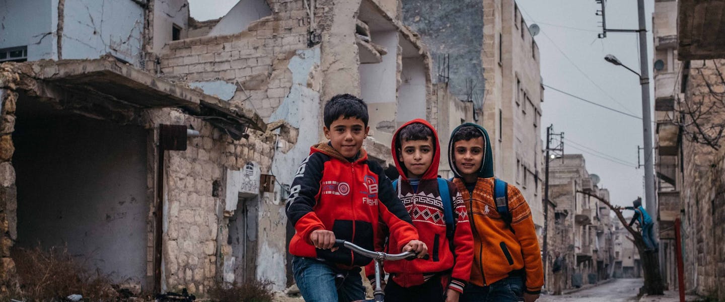 Drie jongens in verwoeste stad Aleppo