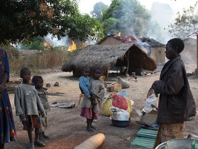 Een familie staat vlakbij een verwoest huis in Bossangoa