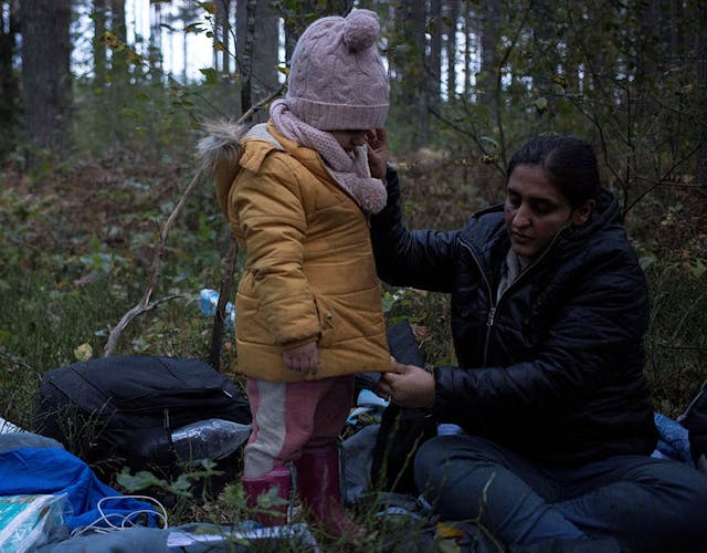 Moeder kleed haar kind aan bij de Wit-Russische grens