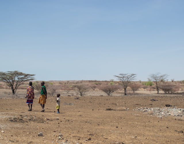 Drie kinderen lopen door vlakte in Kenia