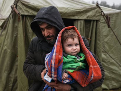 Man houdt zijn dochter vast bij grensgebied van Wit-Rusland en Pol